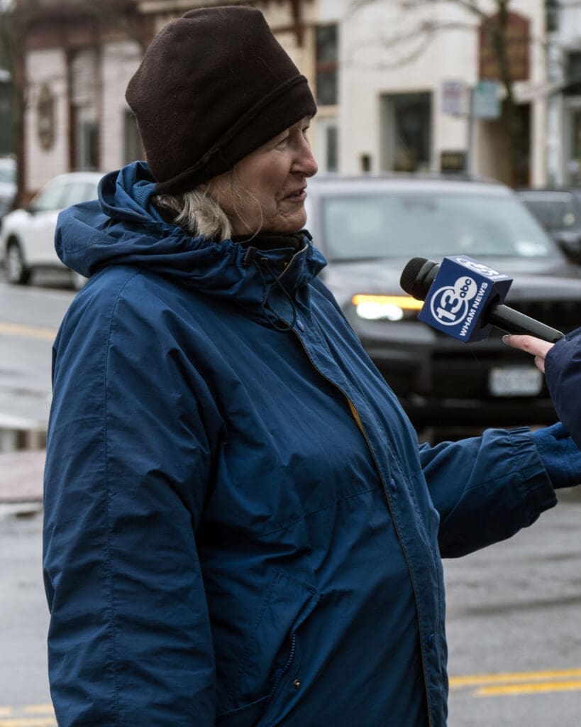Woman in winter jacket interviewed on street.