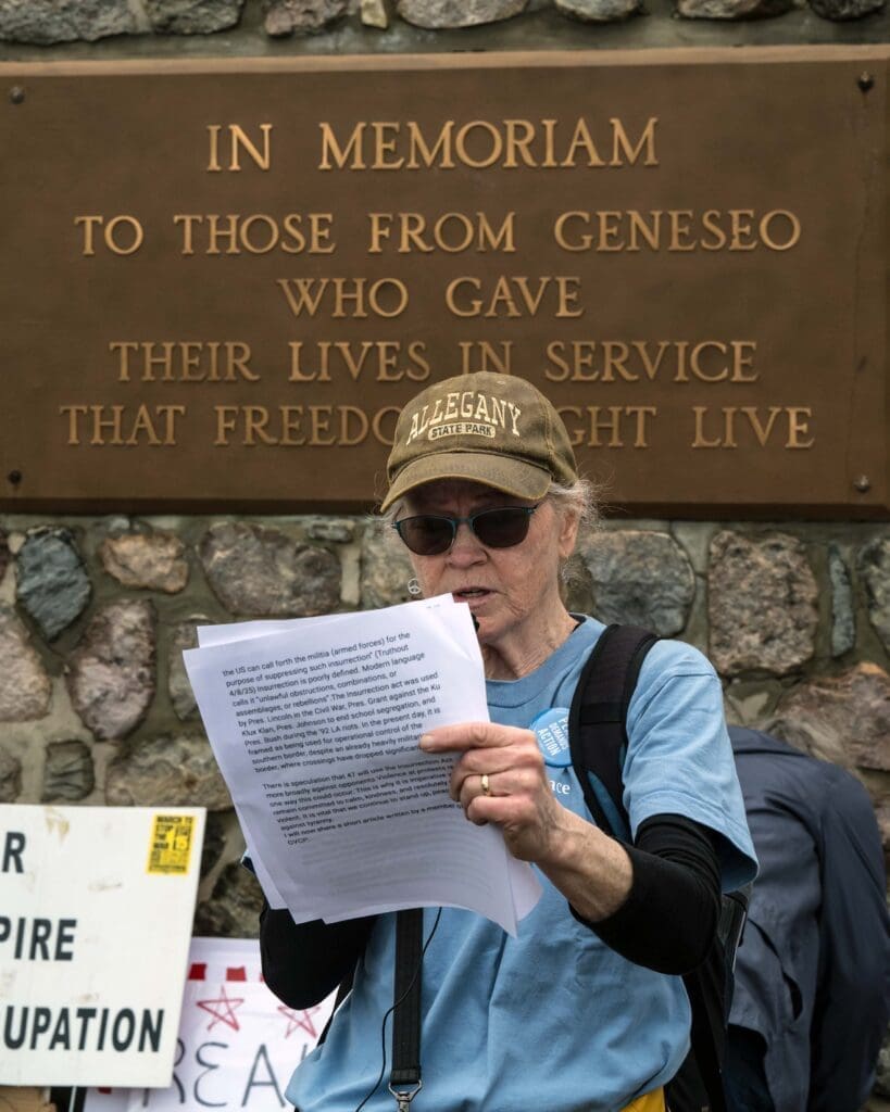 Person reading speech at Geneseo memorial plaque.