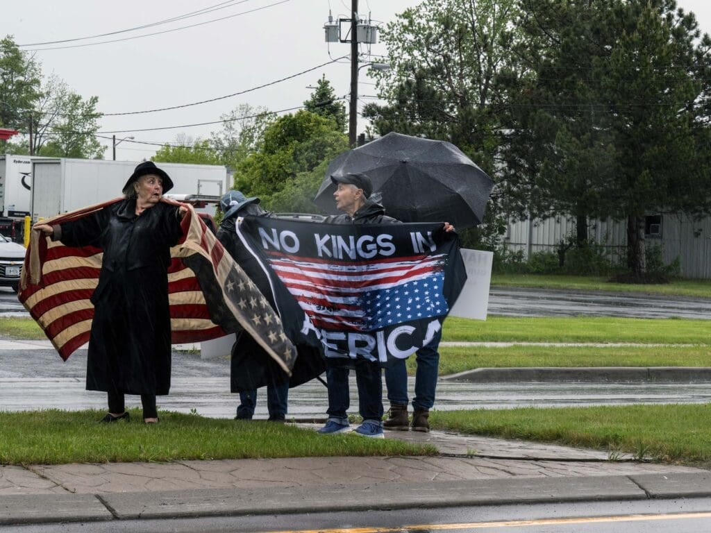 Protestors holding 'No Kings in America' banner.