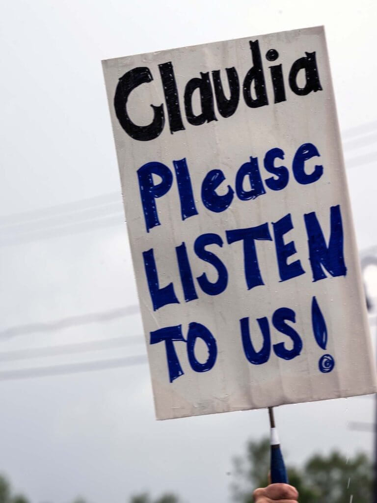 Sign reading 'Claudia Please Listen to Us!'