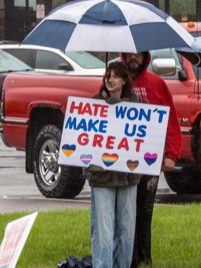 Protesters holding sign: "Hate won't make us great.