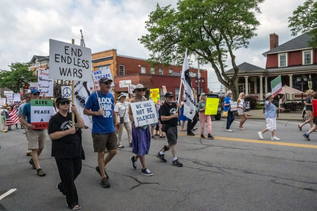 Peaceful marchers with protest signs on street.