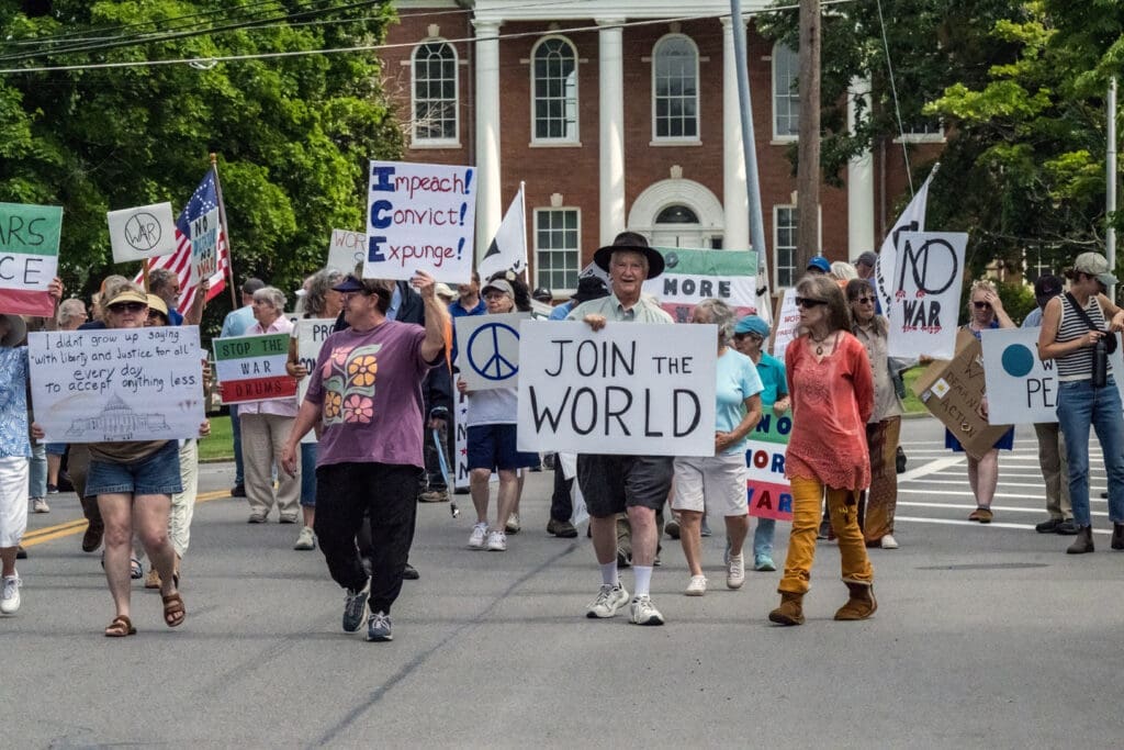 People marching with anti-war signs on street.