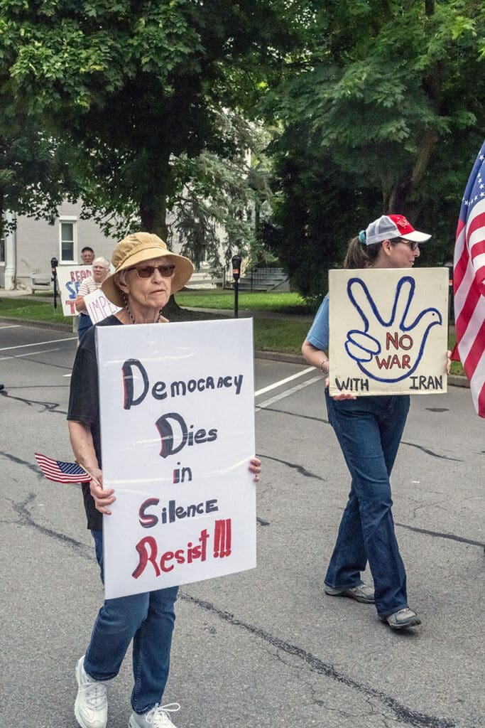 Protesters holding signs for democracy and against war.