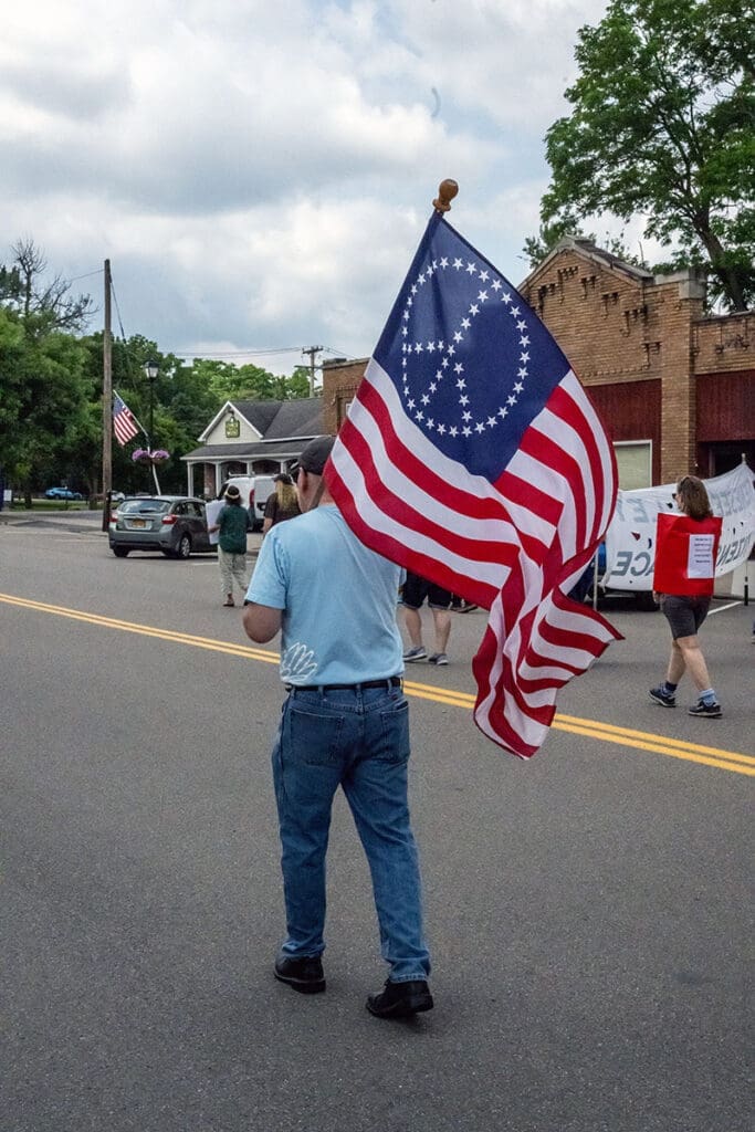 Man carrying American flag with peace symbol