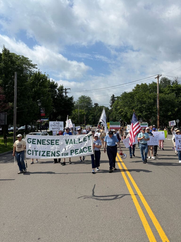 People marching with peace banners on a sunny day.