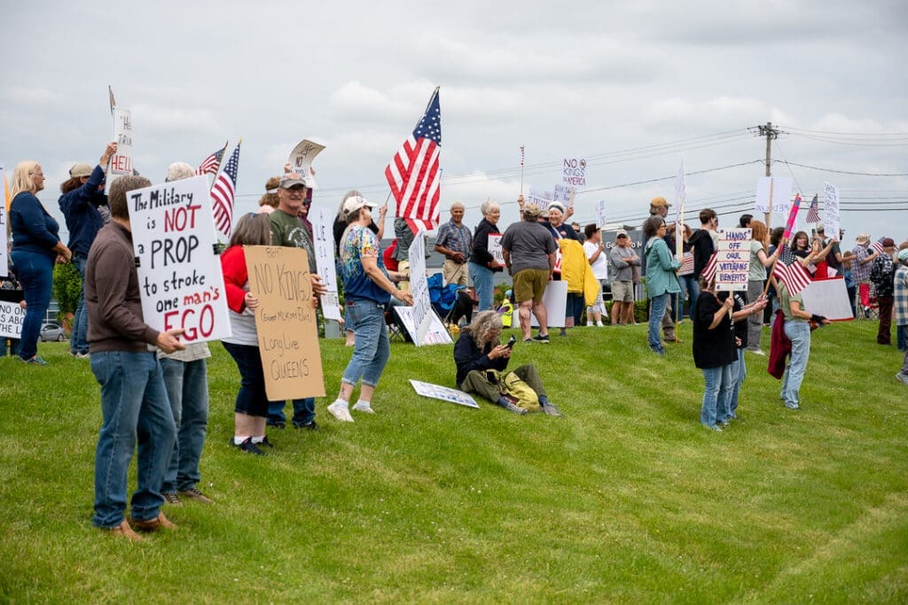 Protesters with signs and flags at a demonstration.