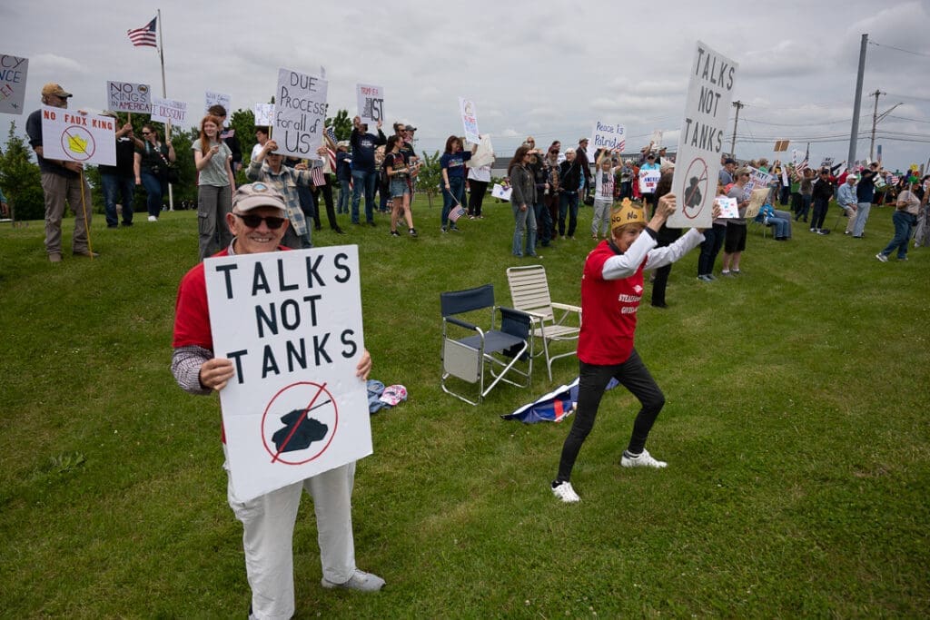 Peaceful protest with anti-war signs on grass field.