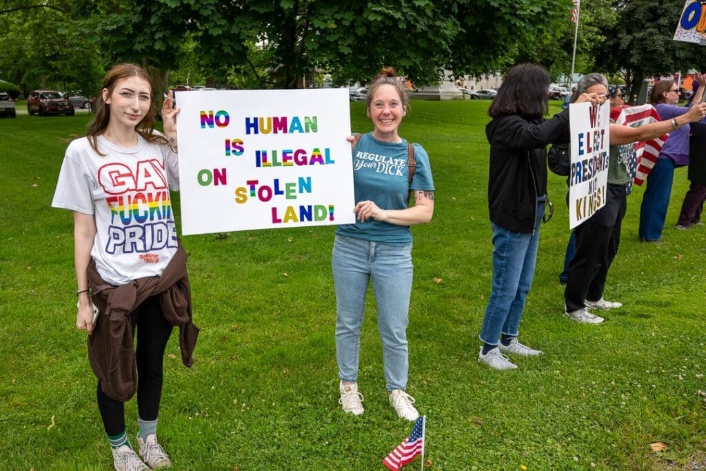 Protestors holding signs in a park.