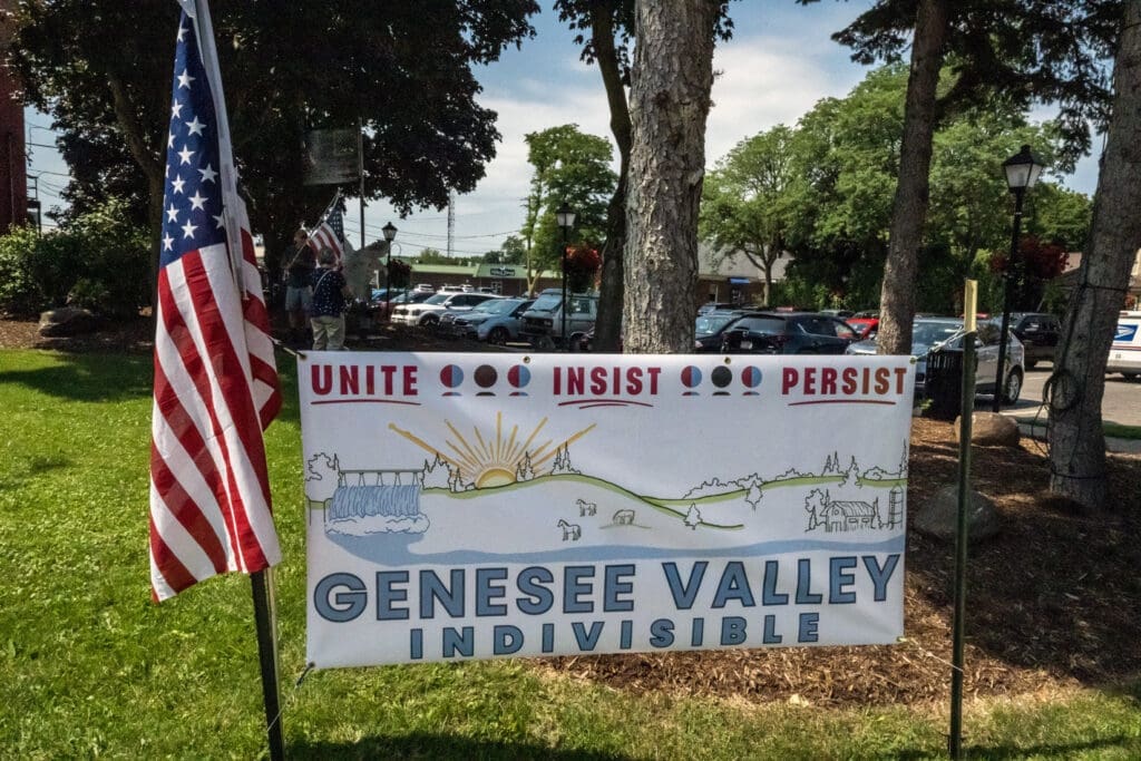 Genesee Valley Indivisible banner and American flag display.