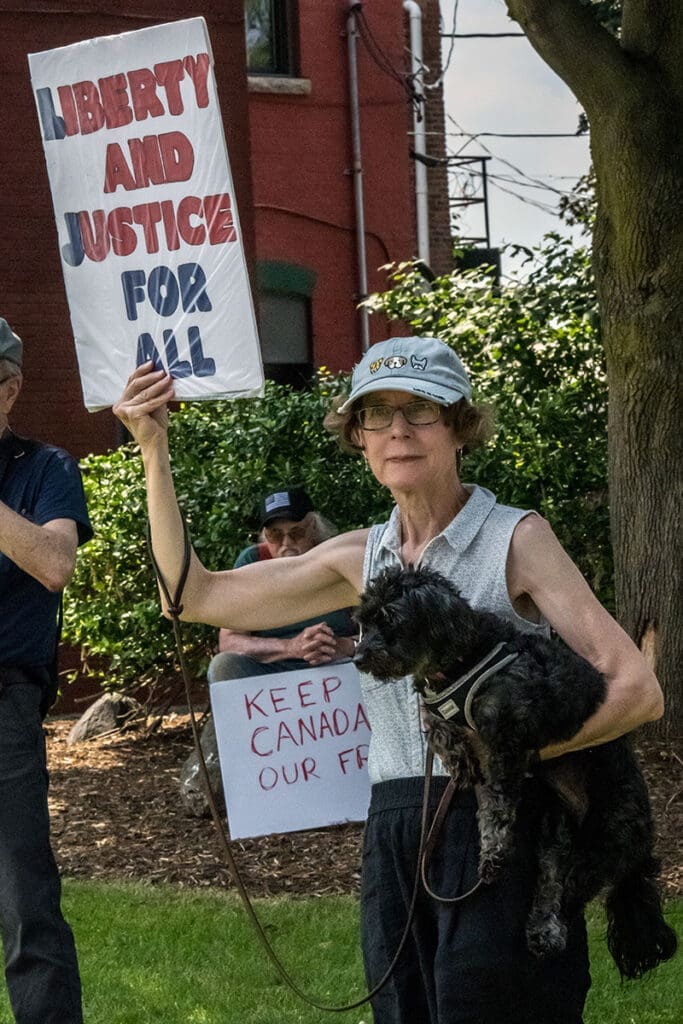 Protester holds 'Liberty and Justice for All' sign.