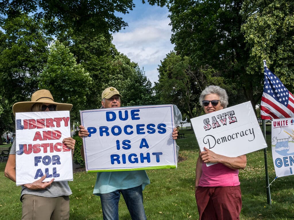 Protesters holding signs for justice and democracy.