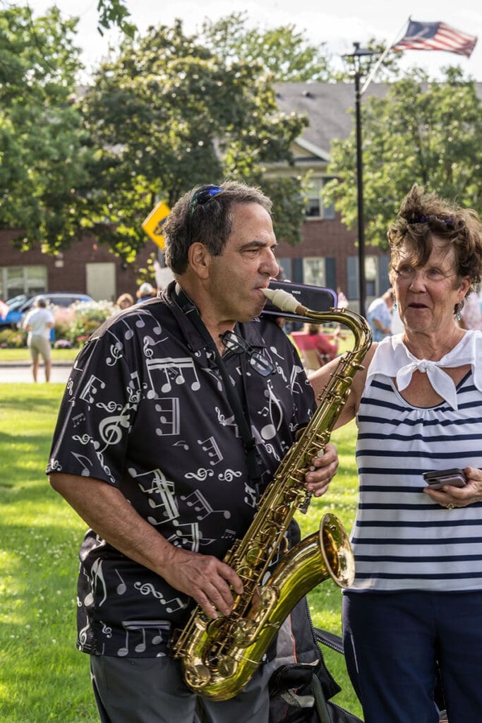 Man playing saxophone outdoors at an event.