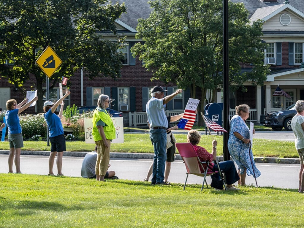 Protesters holding signs and flags outdoors.