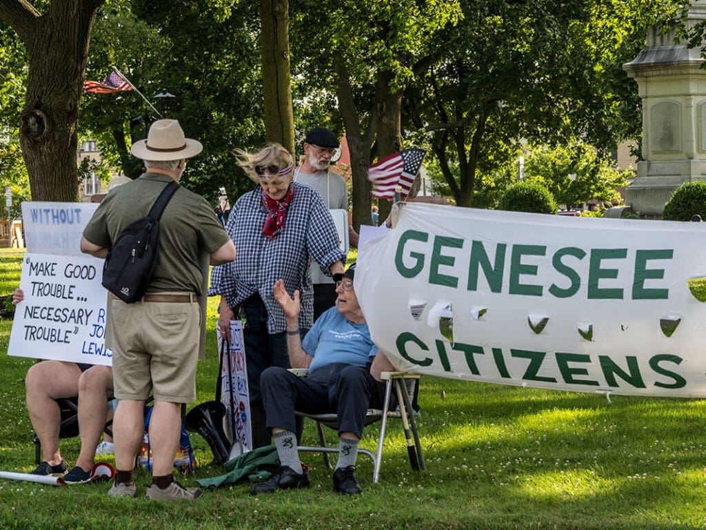 Group gathering with protest signs, Genesee Citizens banner.