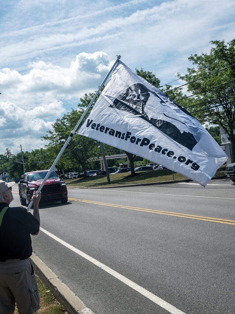 VeteransForPeace.org flag held by person on street