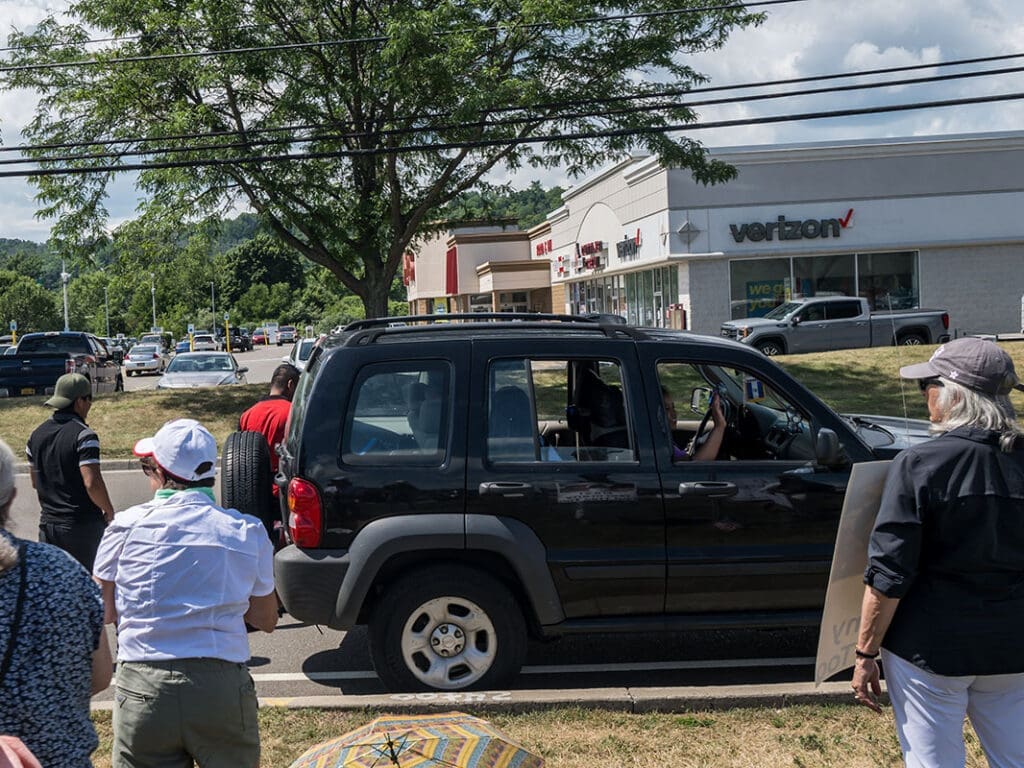 People protesting near Verizon store parking lot.