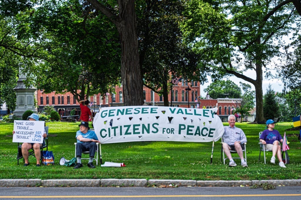 Citizens holding signs for peace rally in park.