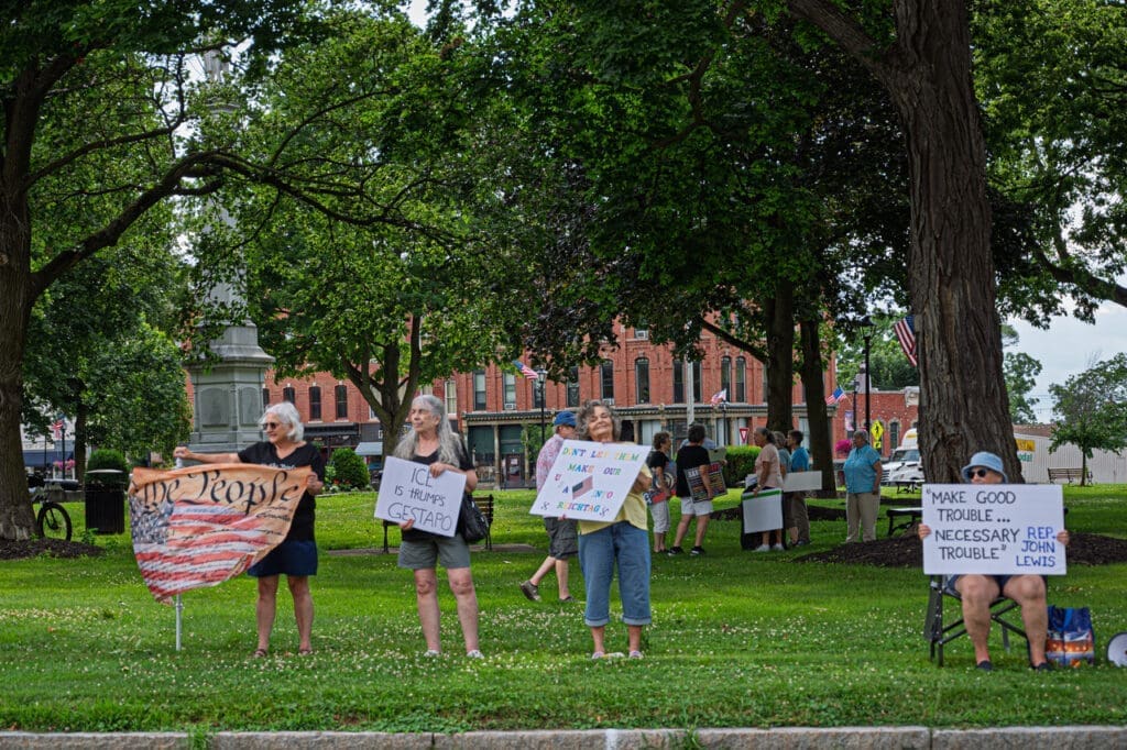 People holding protest signs in a park