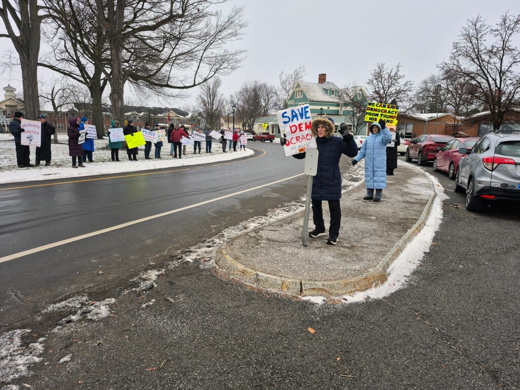Peaceful protest with signs in snowy town street.