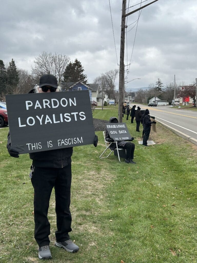 Protesters holding signs on roadside