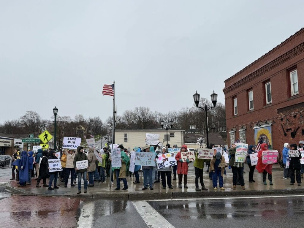 Group protesting with signs in a town square.