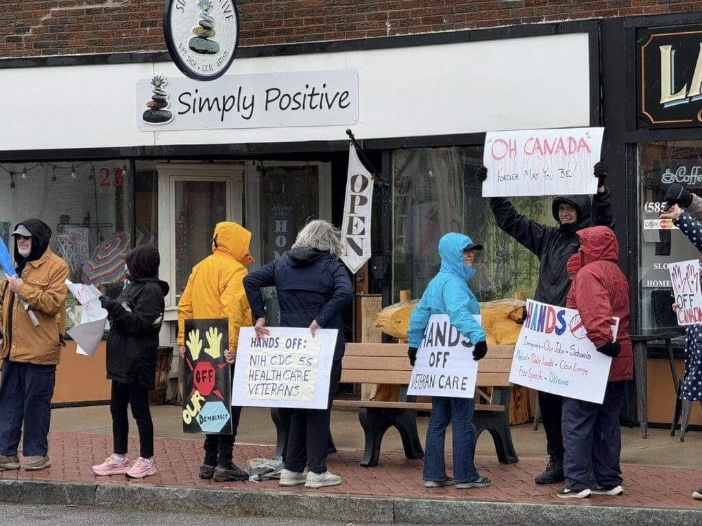 Protesters with signs outside Simply Positive shop.