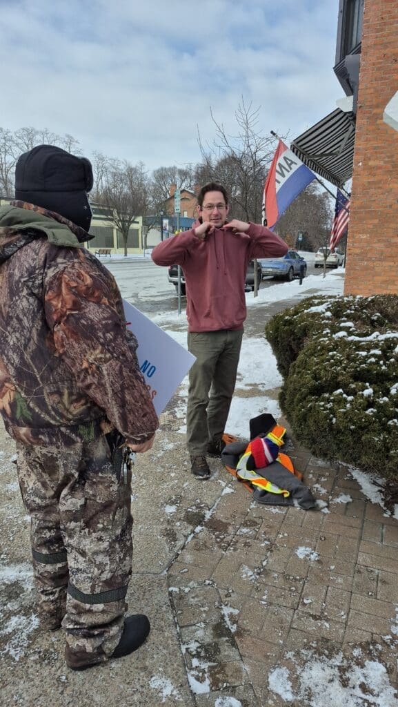 Two people talking outside in winter clothing.