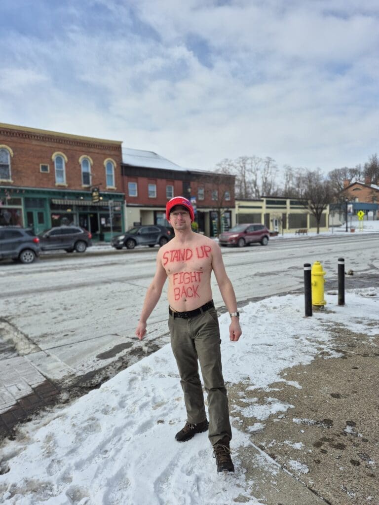 Man outside with protest message on chest in winter.