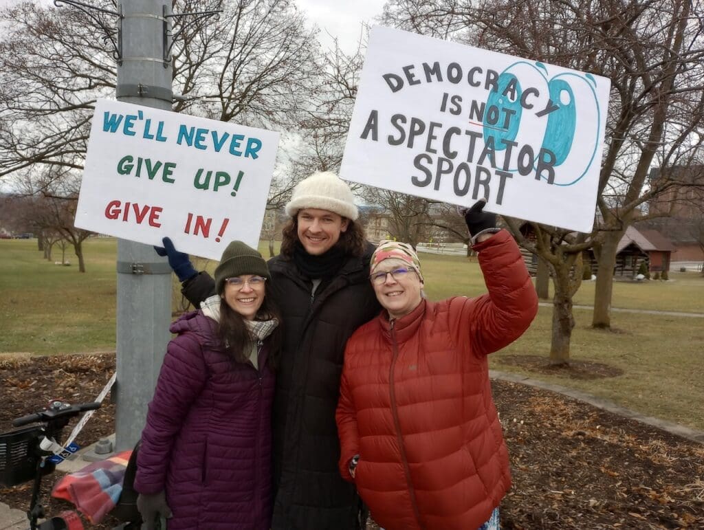 Protesters holding signs advocating for democracy.