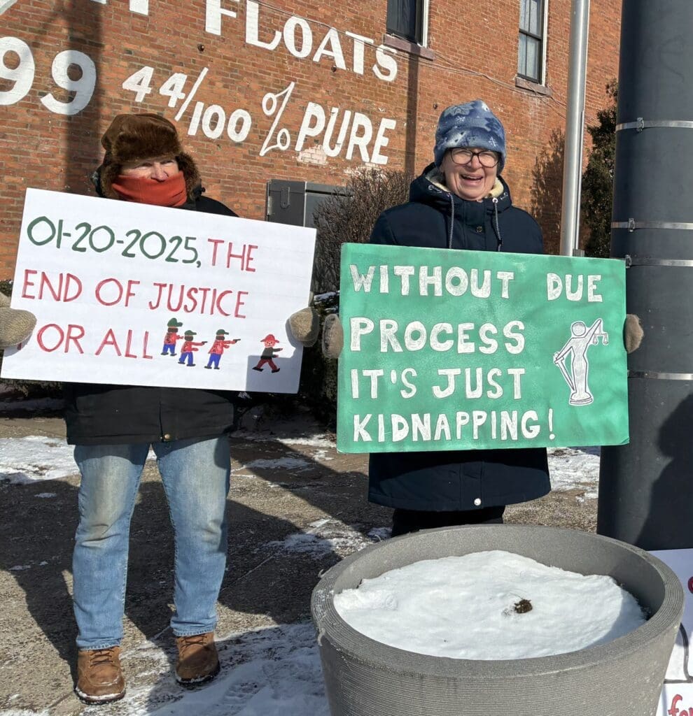 Two people holding protest signs about justice.