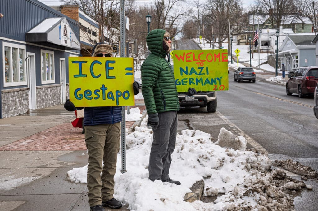 Protesters holding signs comparing ICE to Nazis.