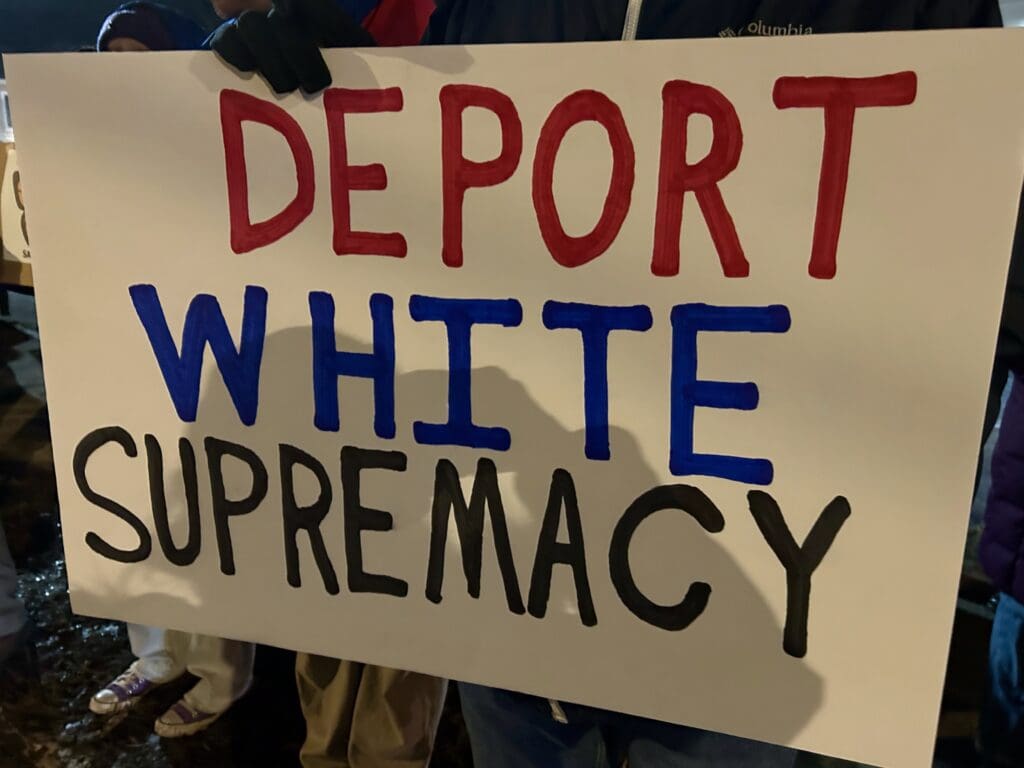 Sign reading 'Deport White Supremacy' at protest