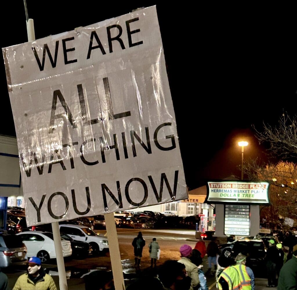 Protest sign 'We are all watching you now'