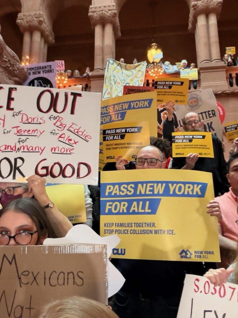 Protesters holding signs for immigrant rights in New York.