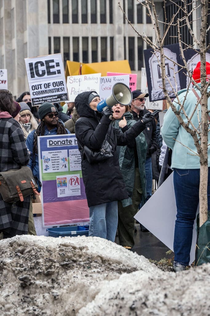 People protesting with signs in winter clothing.