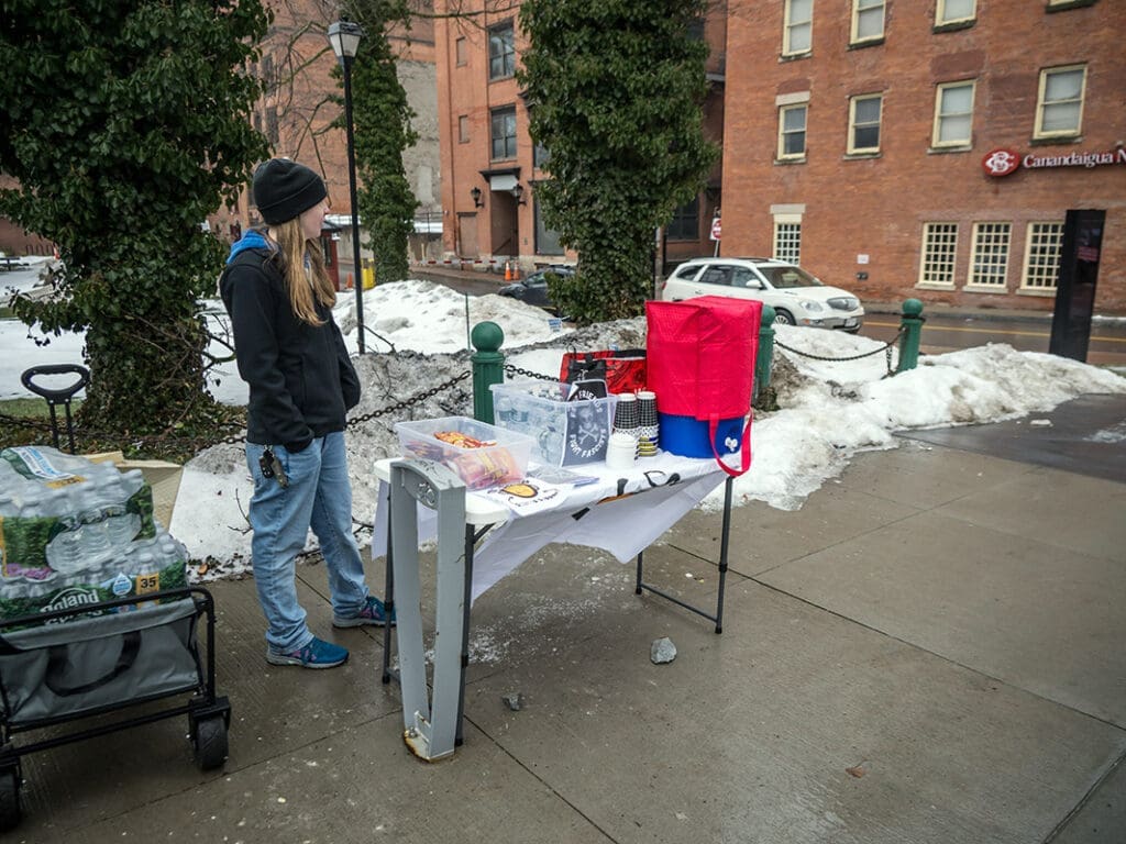 Outdoor vendor stand with water and snacks in winter.