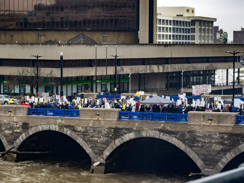 Crowd protesting on a bridge downtown.