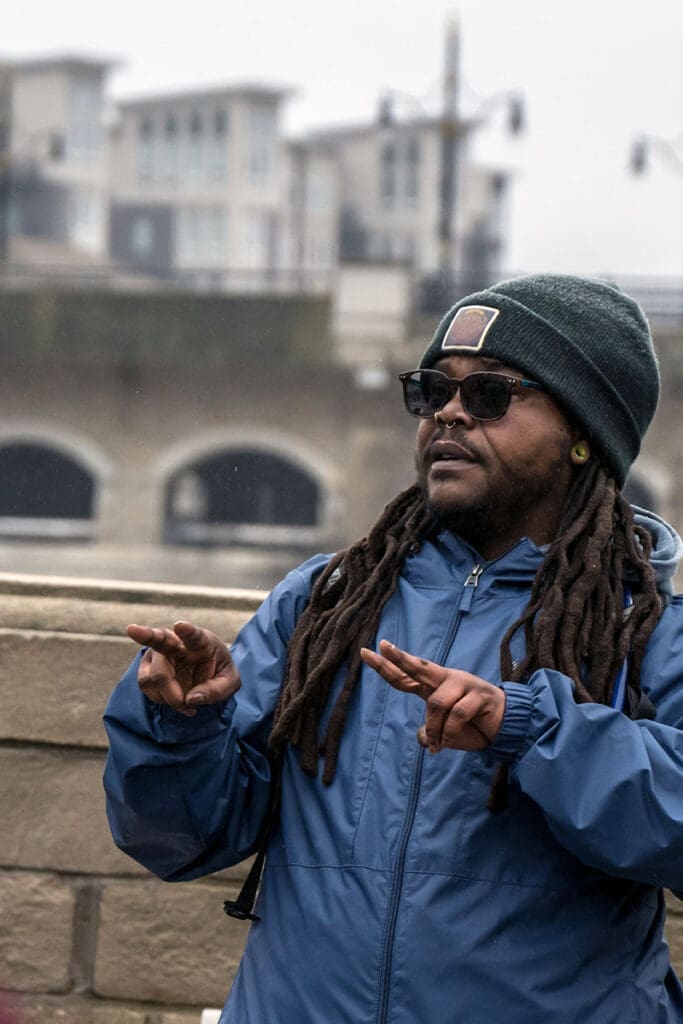 Man gesturing in urban outdoor setting.