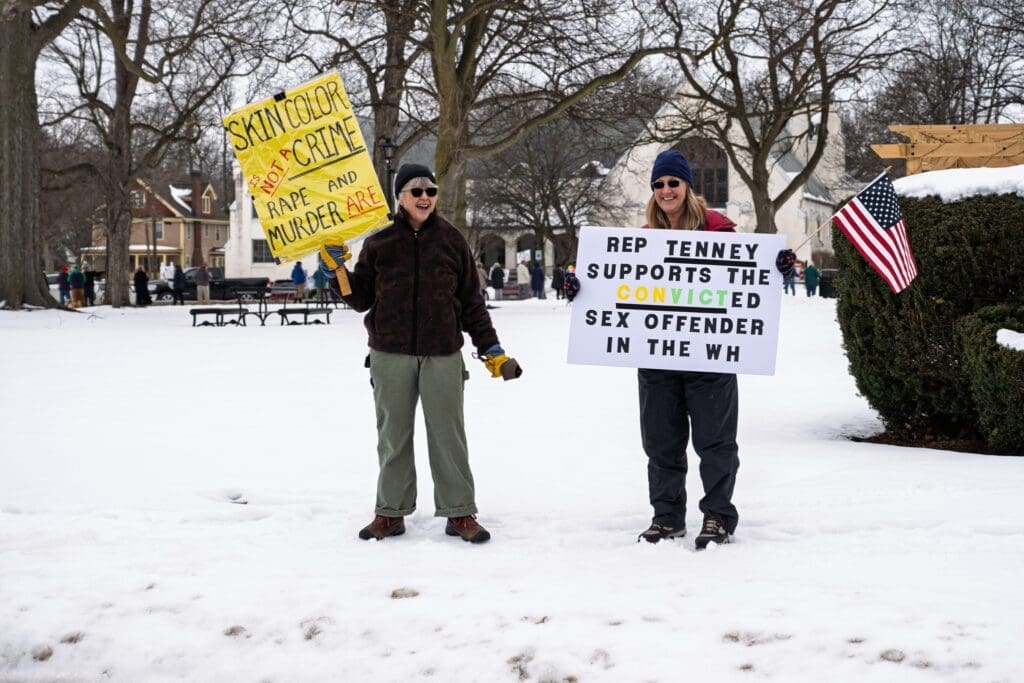 Protesters holding signs on snowy day.
