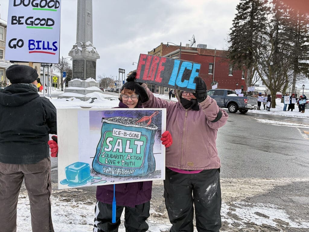 People holding signs at snowy protest.