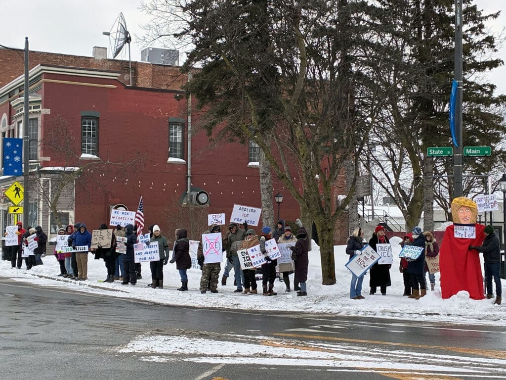 Protesters holding signs in snowy street demonstration.