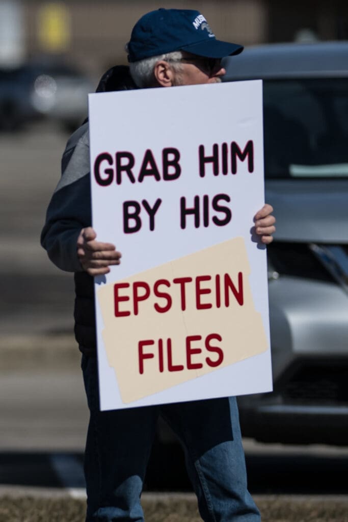 Protester holding sign demanding release of Epstein files