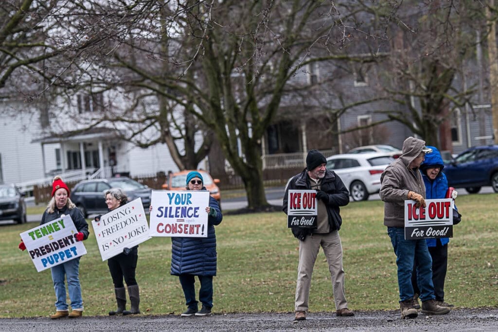Protesters holding political signs in neighborhood park