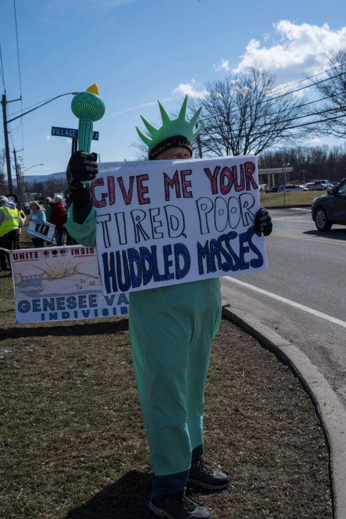 Statue of Liberty protester holding immigration protest sign