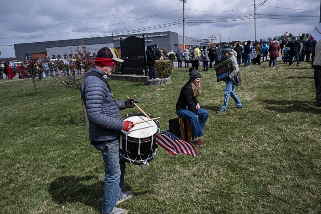 Man playing drum at outdoor protest gathering
