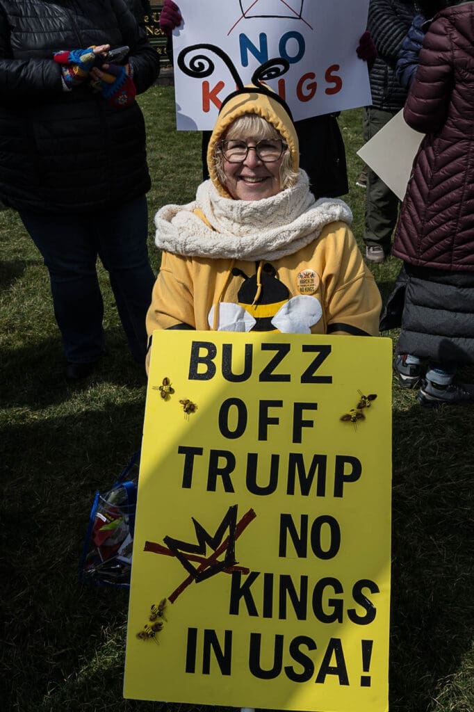 Protester in bee costume holding anti-Trump sign