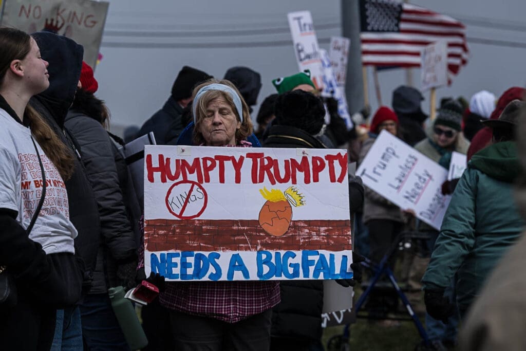 Protester holding 'Humpty Trumpty Needs a Big Fall' sign