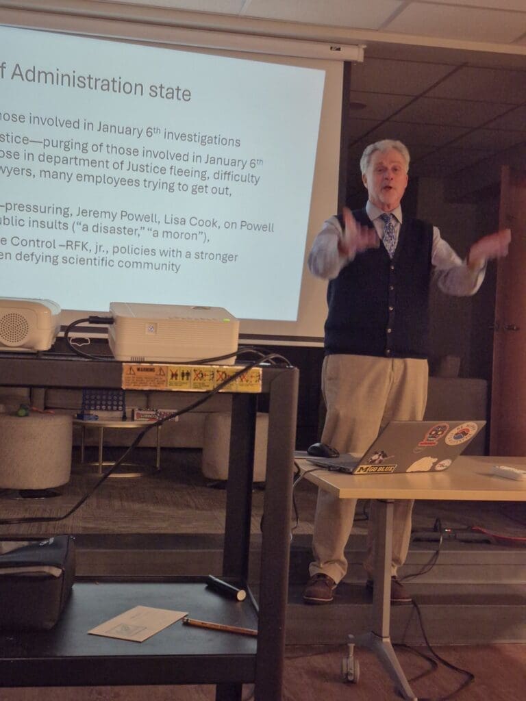Man giving presentation with projected political slide