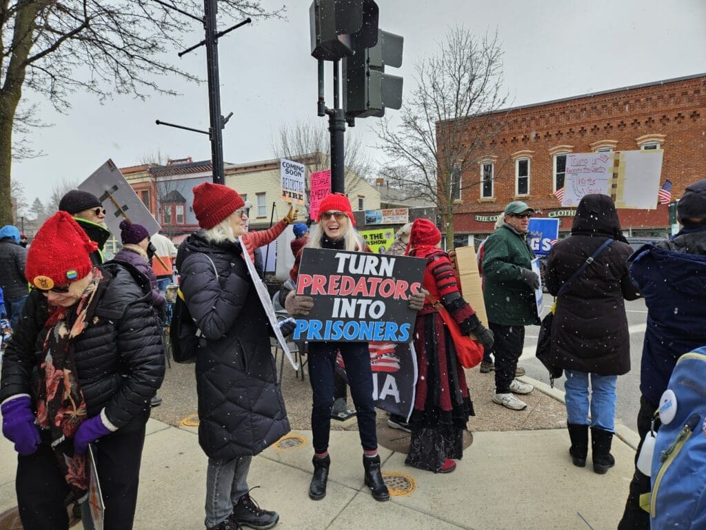 Protesters holding signs at snowy downtown rally